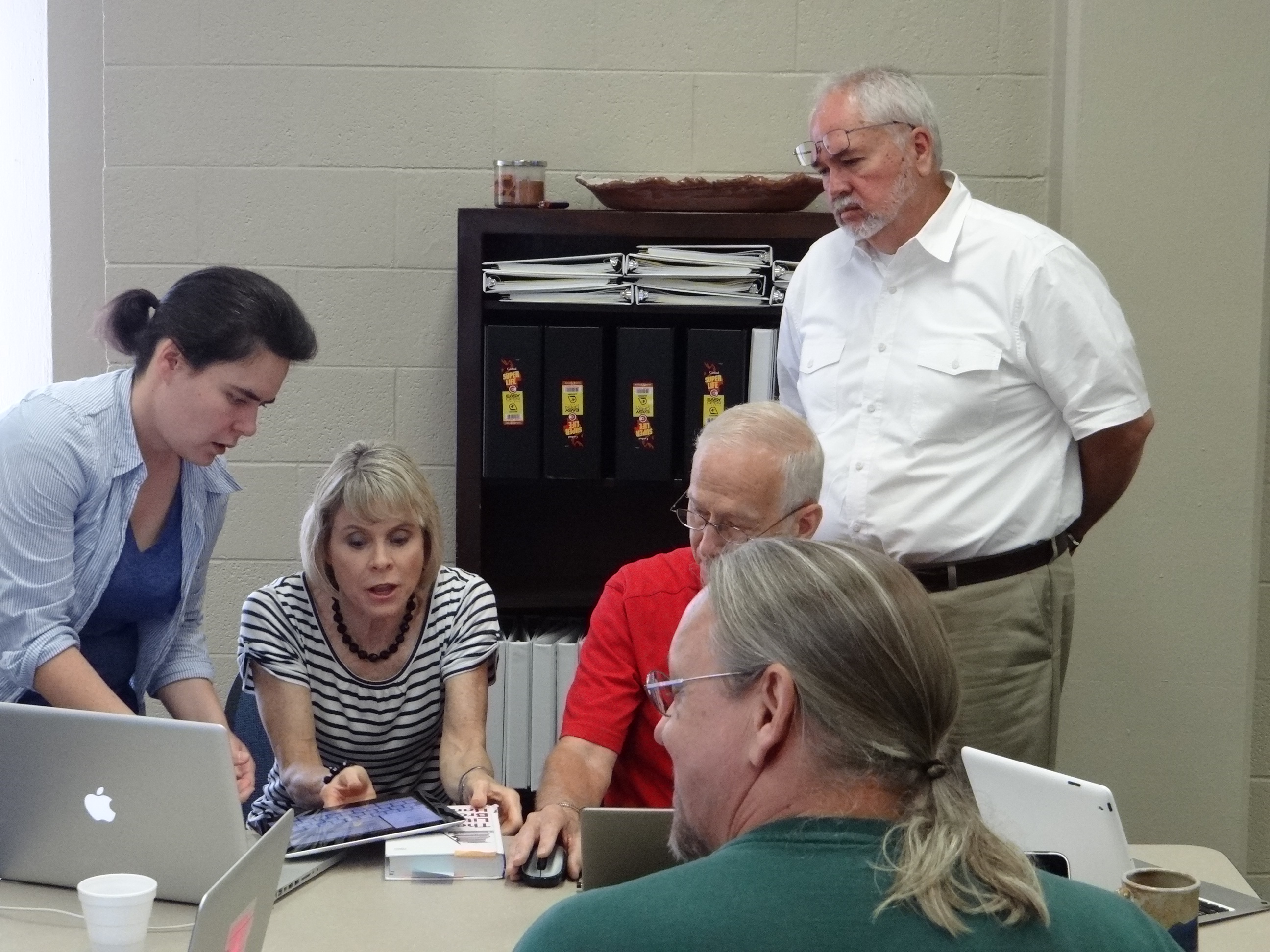 Phooto of Faculty and Staff gathered around an iPad