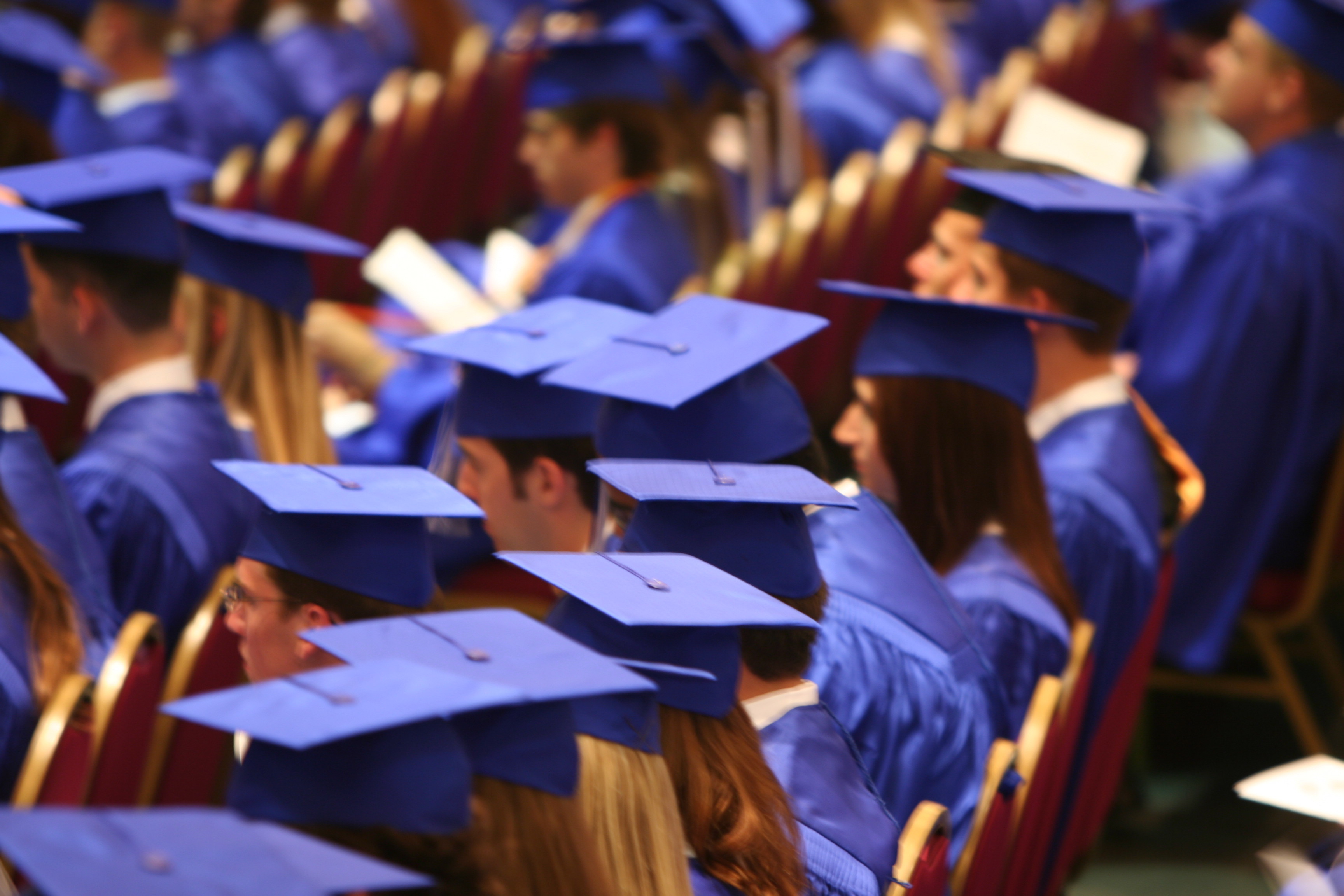 Photo of students wearing mortar boards at graduation.