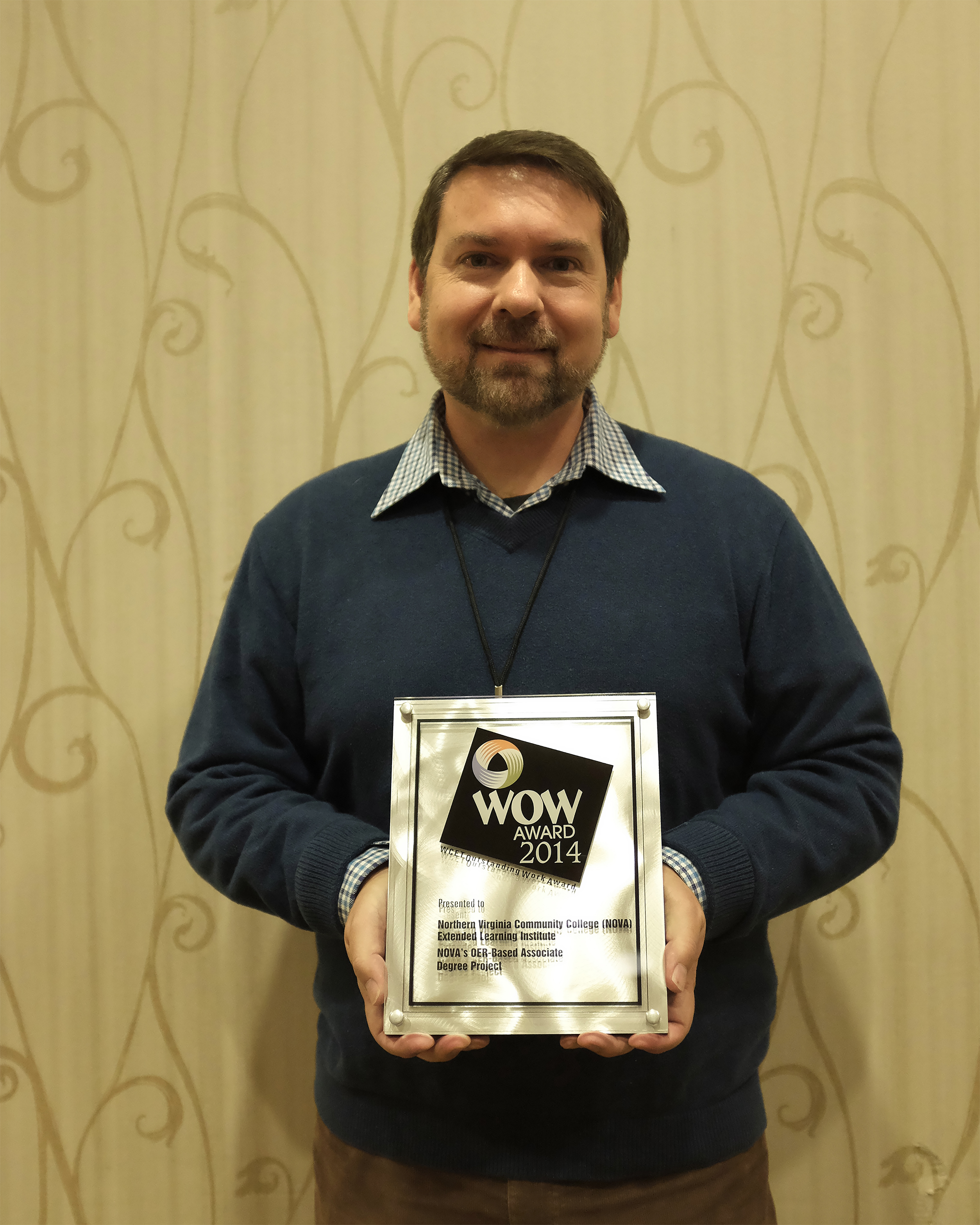 Preston Davis holding a WCET WOW Award.