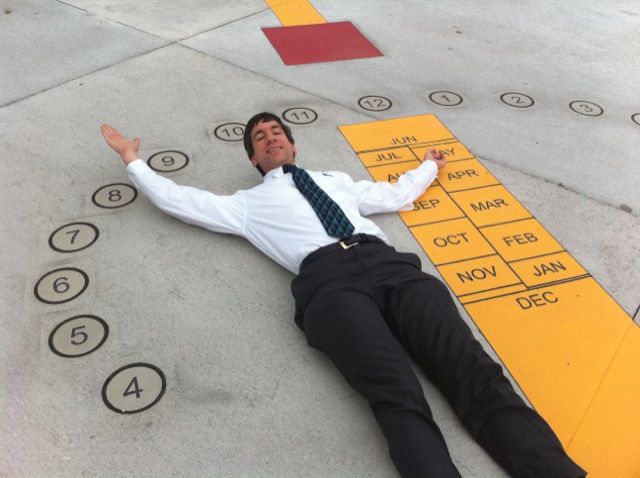 Joseph Kerski laying on a sundial