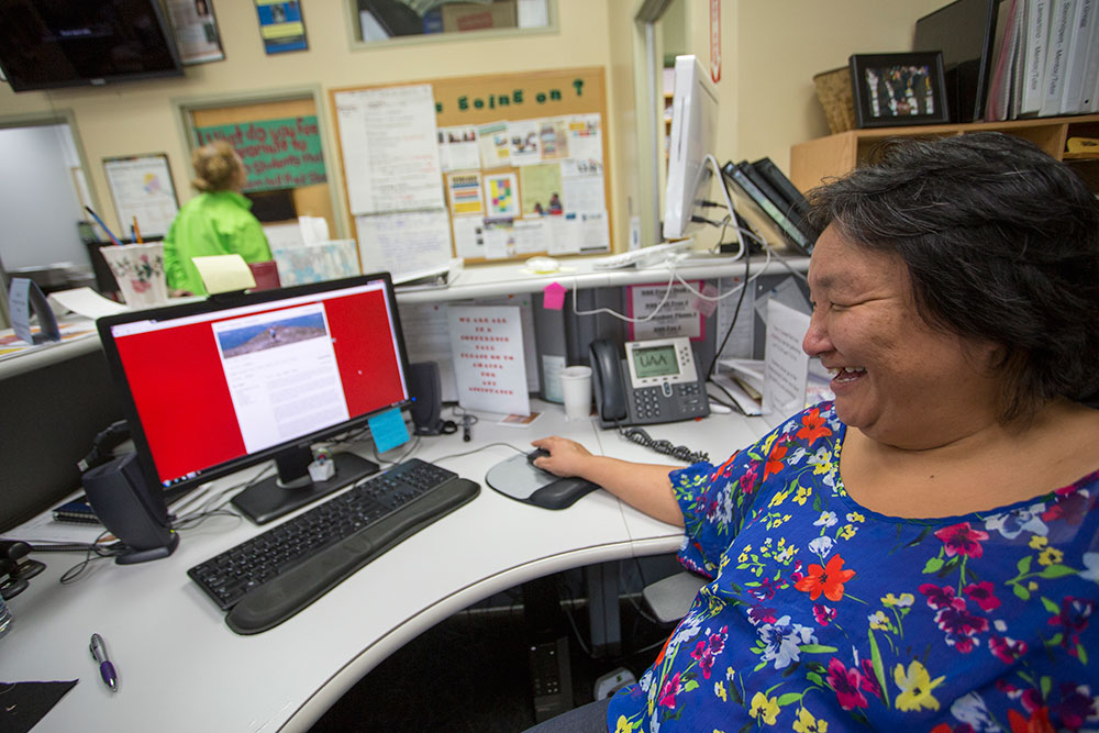 Sporting a broad smile, Eva is shown at a computer with her eportfolio on the screen.