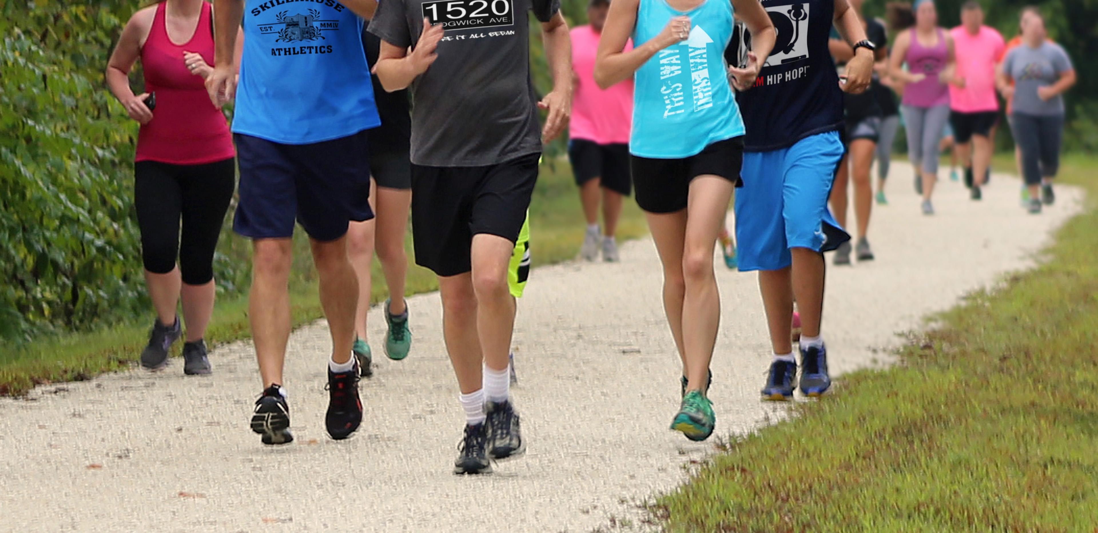 photo of different sizes of people all jogging down a track.