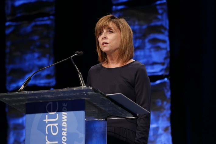 Photo of Kathleen Ives speaking at a podium