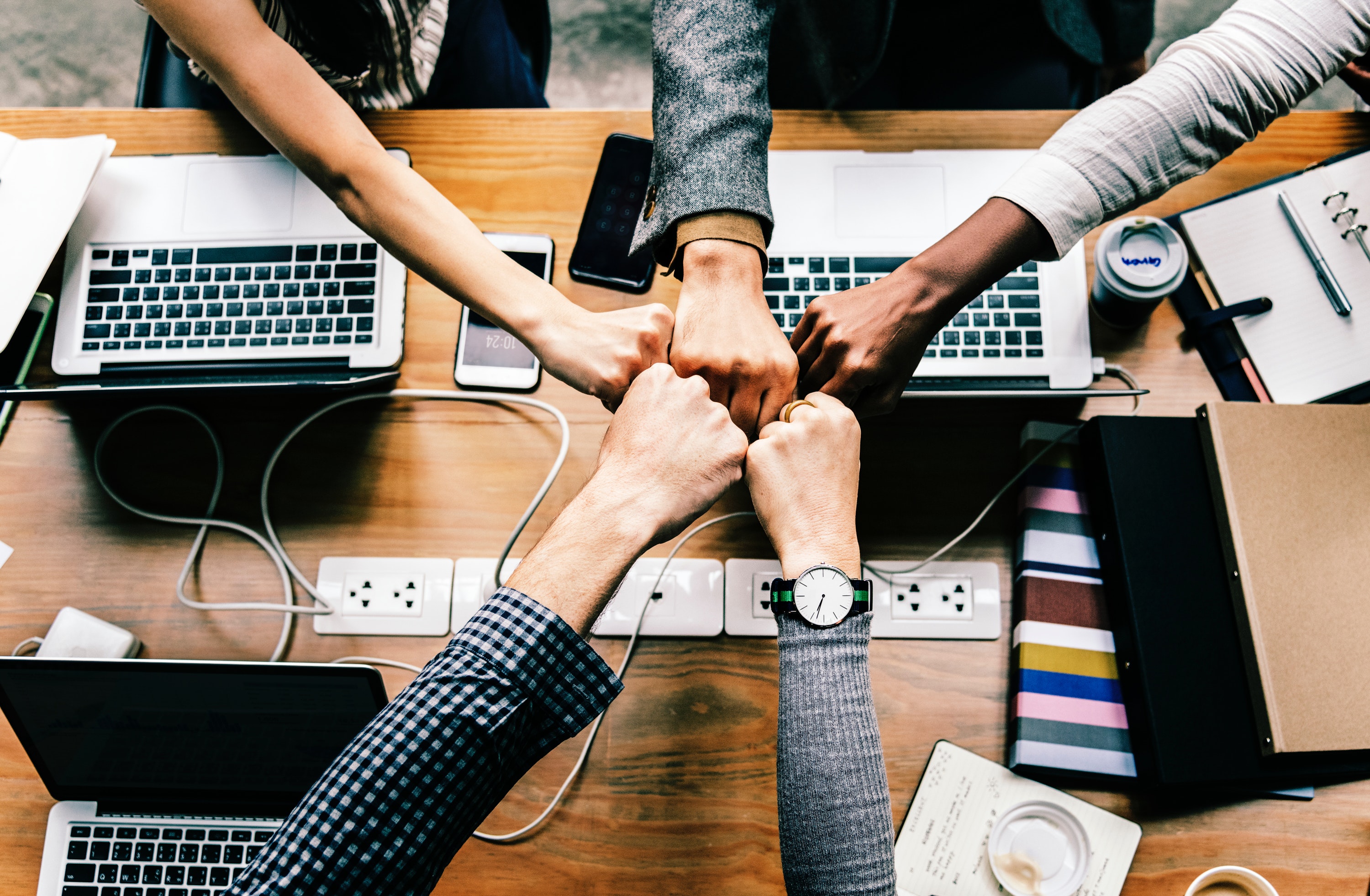 Picture of five people putting their fists together.