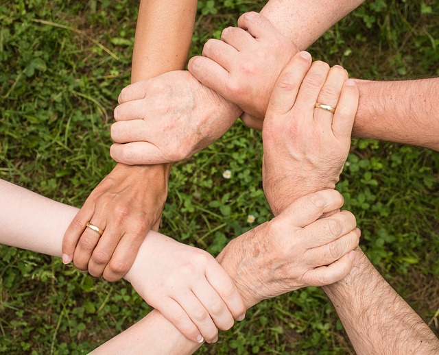 Picture of five people holding hands. Their hands represent a circle form.