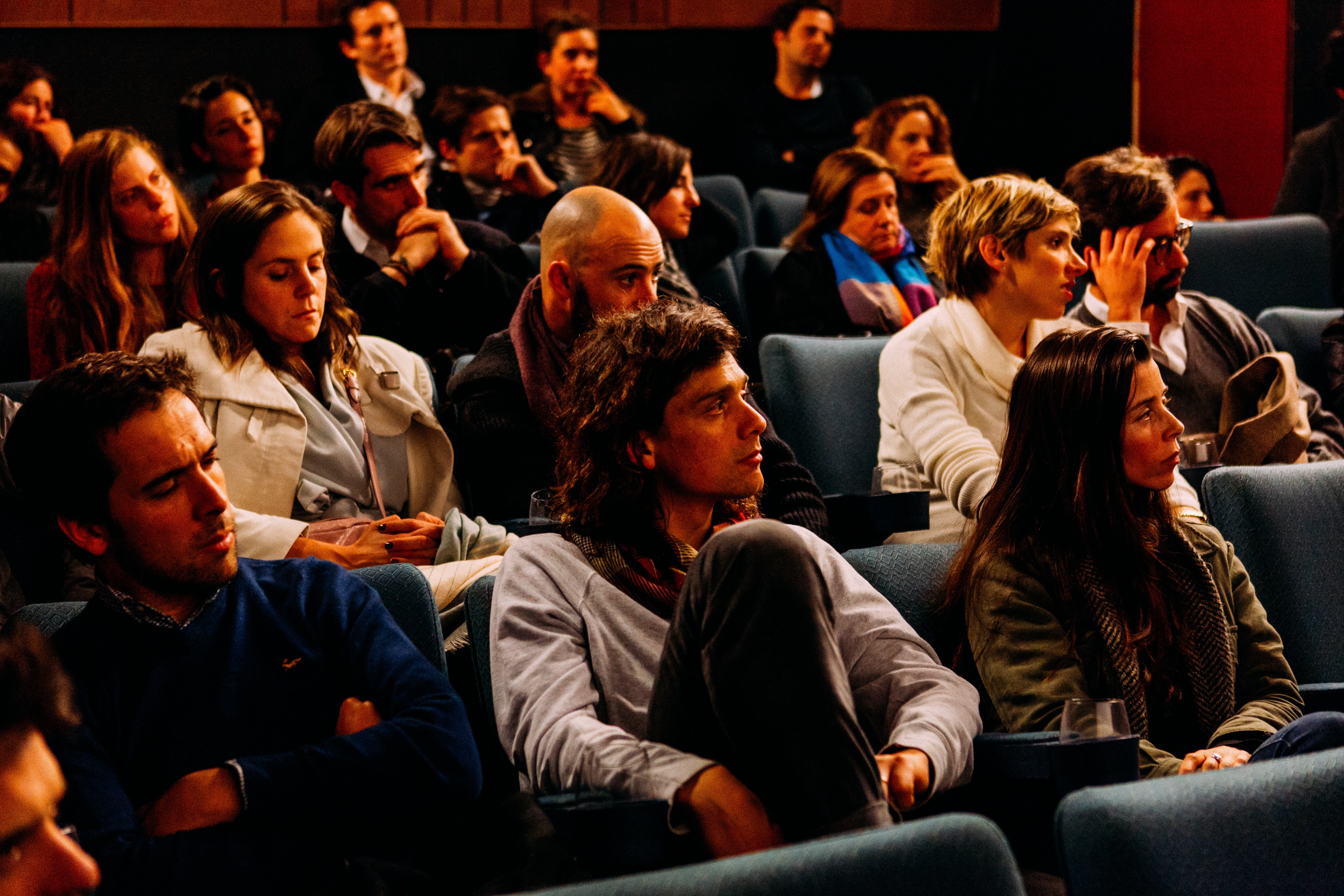 Photo of an audience of mend and women watching something in front of them.