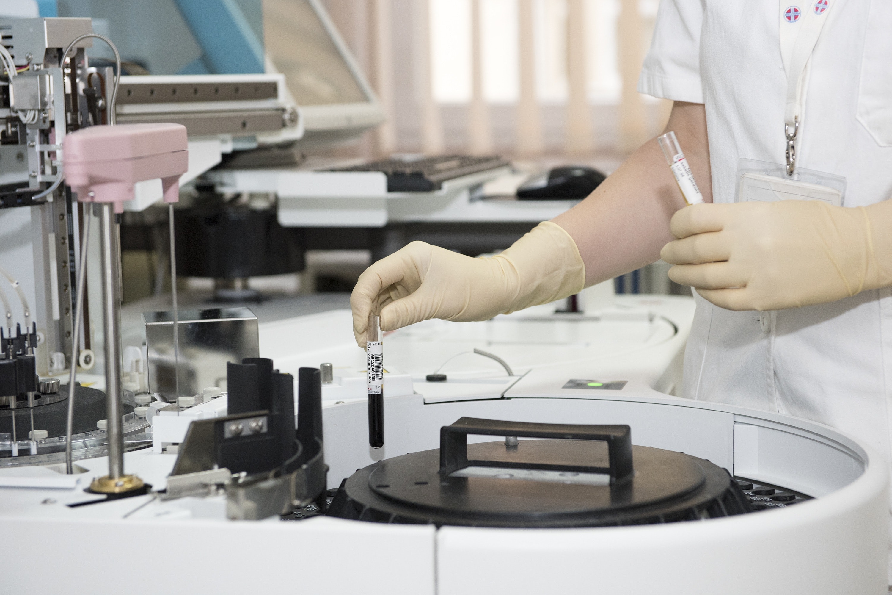 A medical tech works with a medical vial