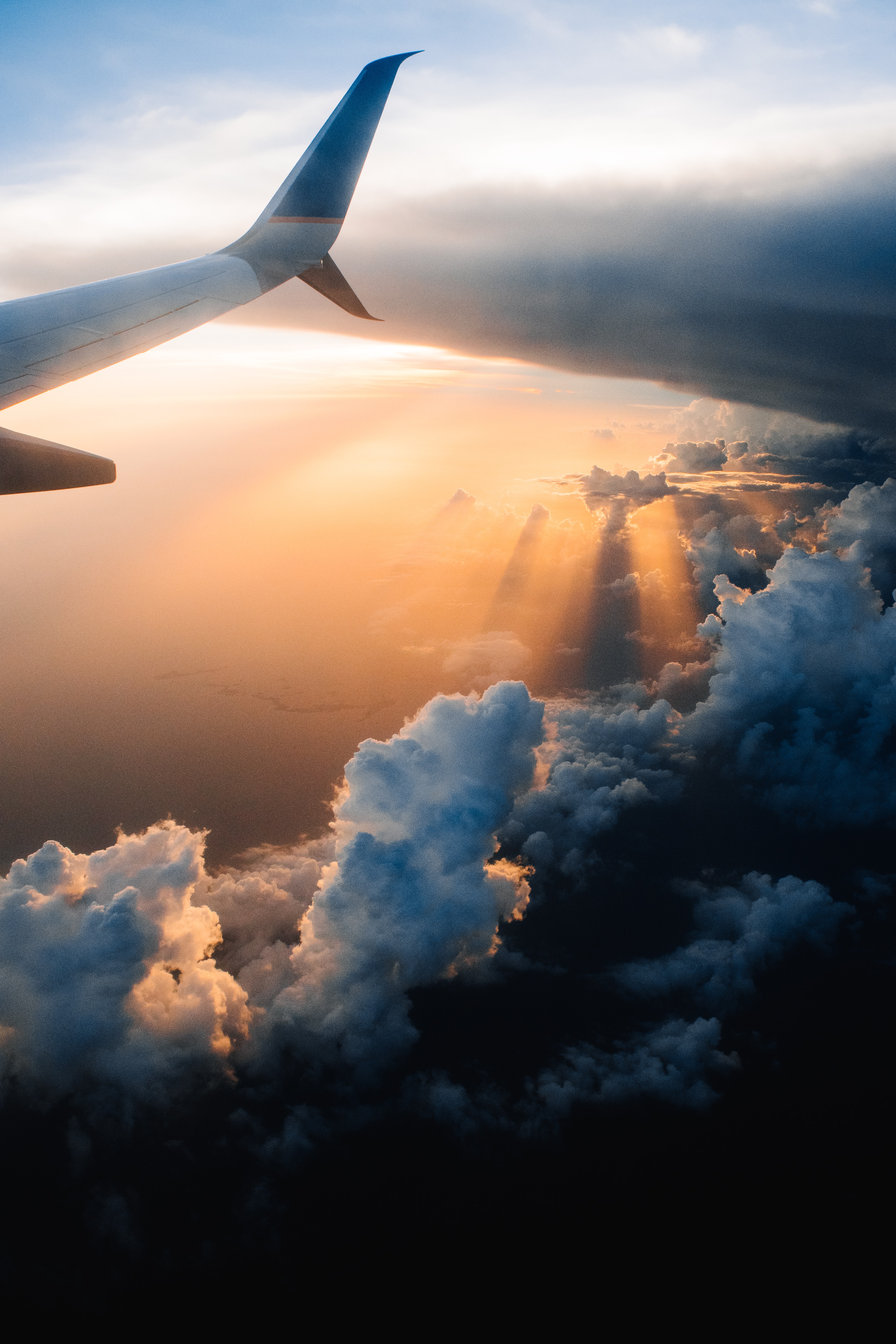 The tail of an airplane flying over a storm