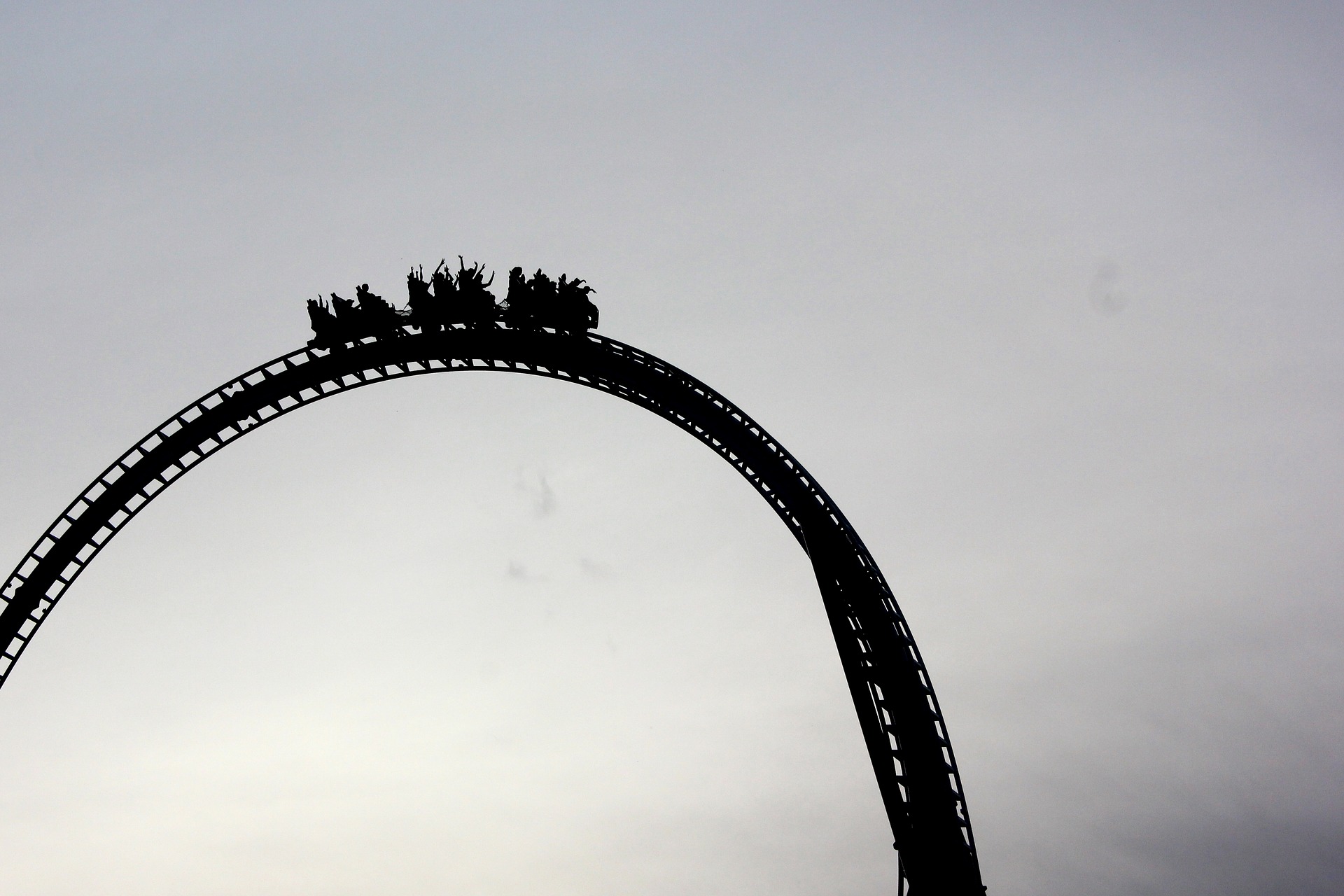 A roller coaster cart filled with people about to go over a long drop