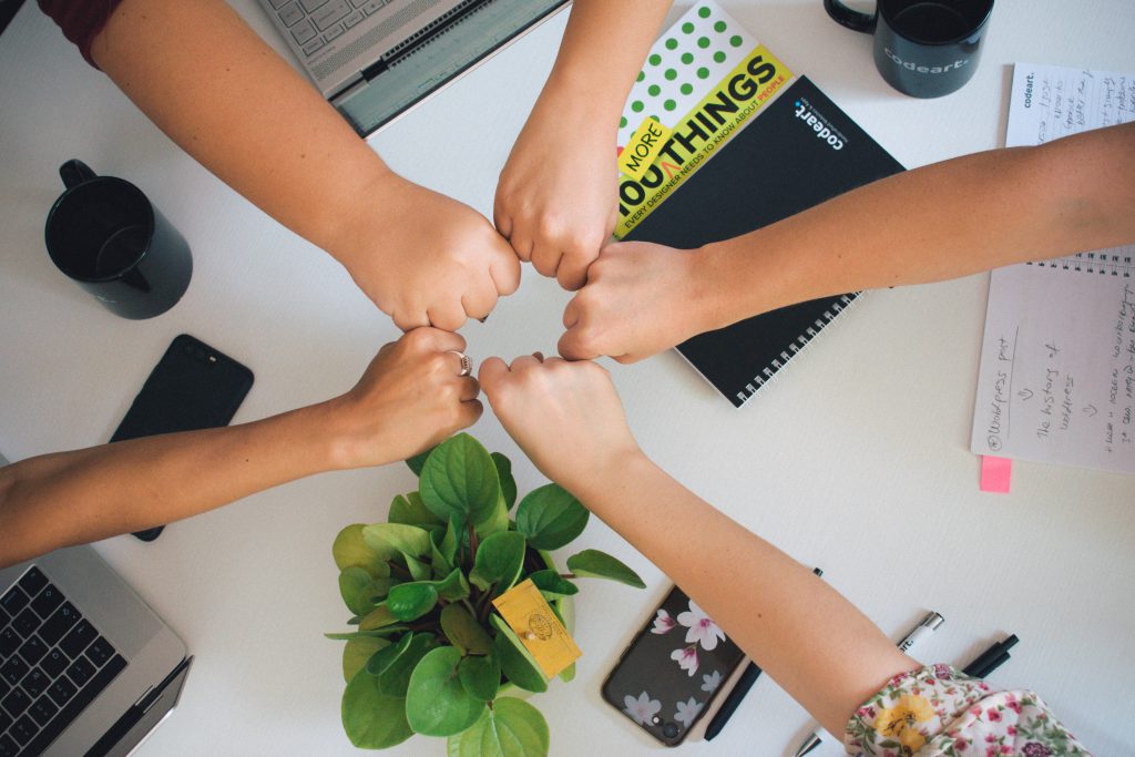 Several people fist bump each other.