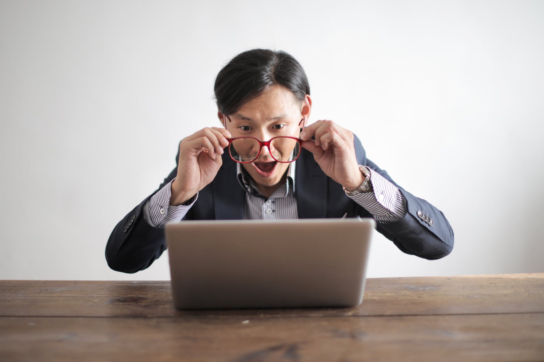 man looking at a laptop in surprise