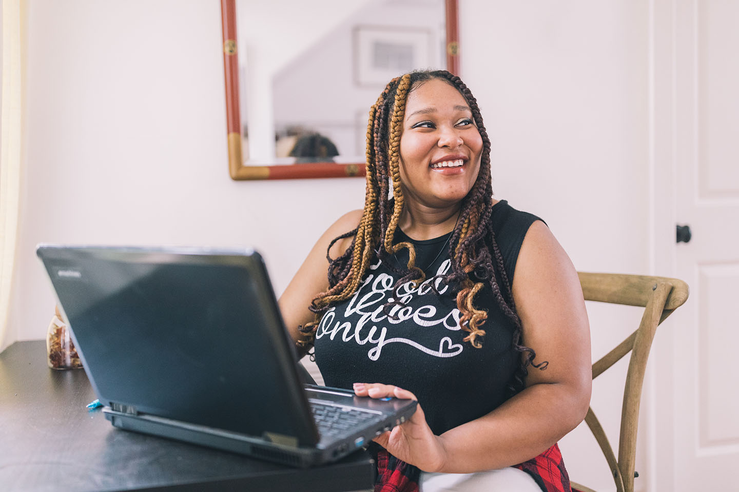 Woman smiles while using a laptop