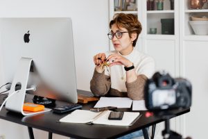 confident elegant lady in eyeglasses looking at a computer