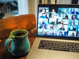 several people attending a video conference call on a lapt