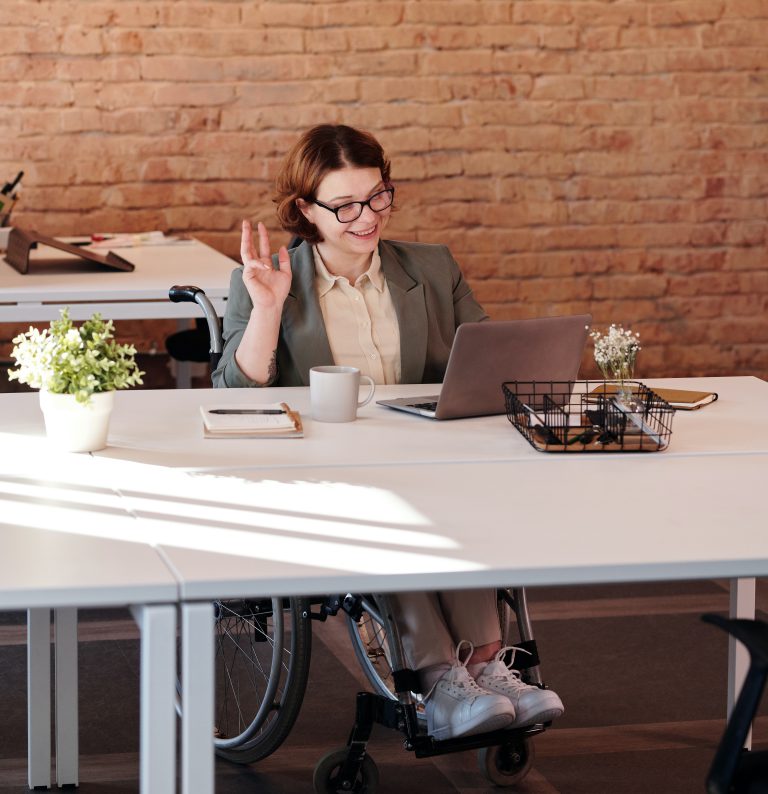 woman waving toward a laptop