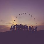 Group of graduates throwing their hats in the air.