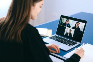 student working on a laptop with others, virtually