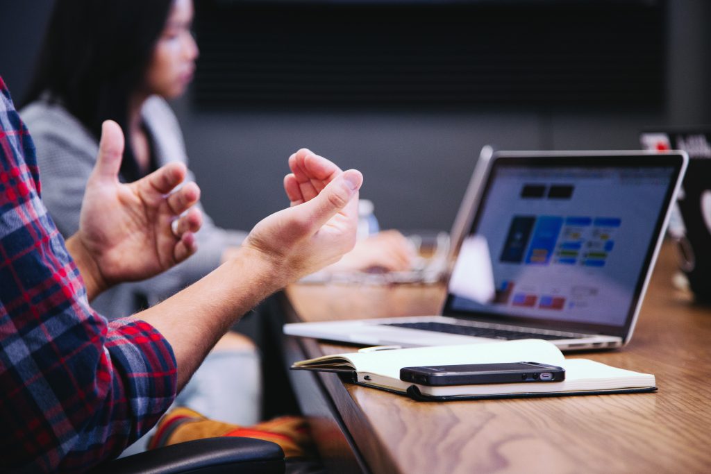 person gestures to laptop screen
