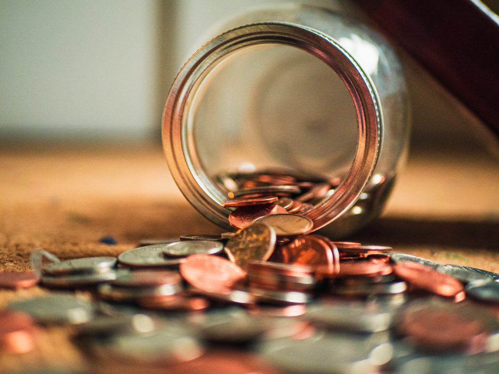 Image of a jar spilling coins onto a table